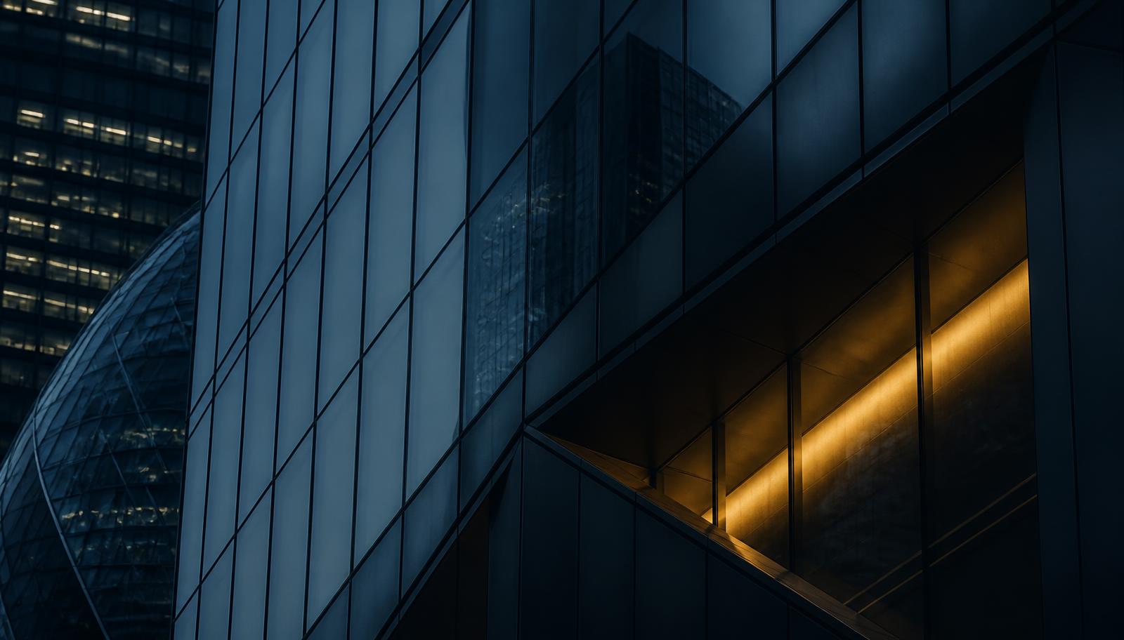 Dark navy glass facade of a City of London financial building with a gold light accent, illustrating the new FCA authorisation regime for UK cryptoasset firms